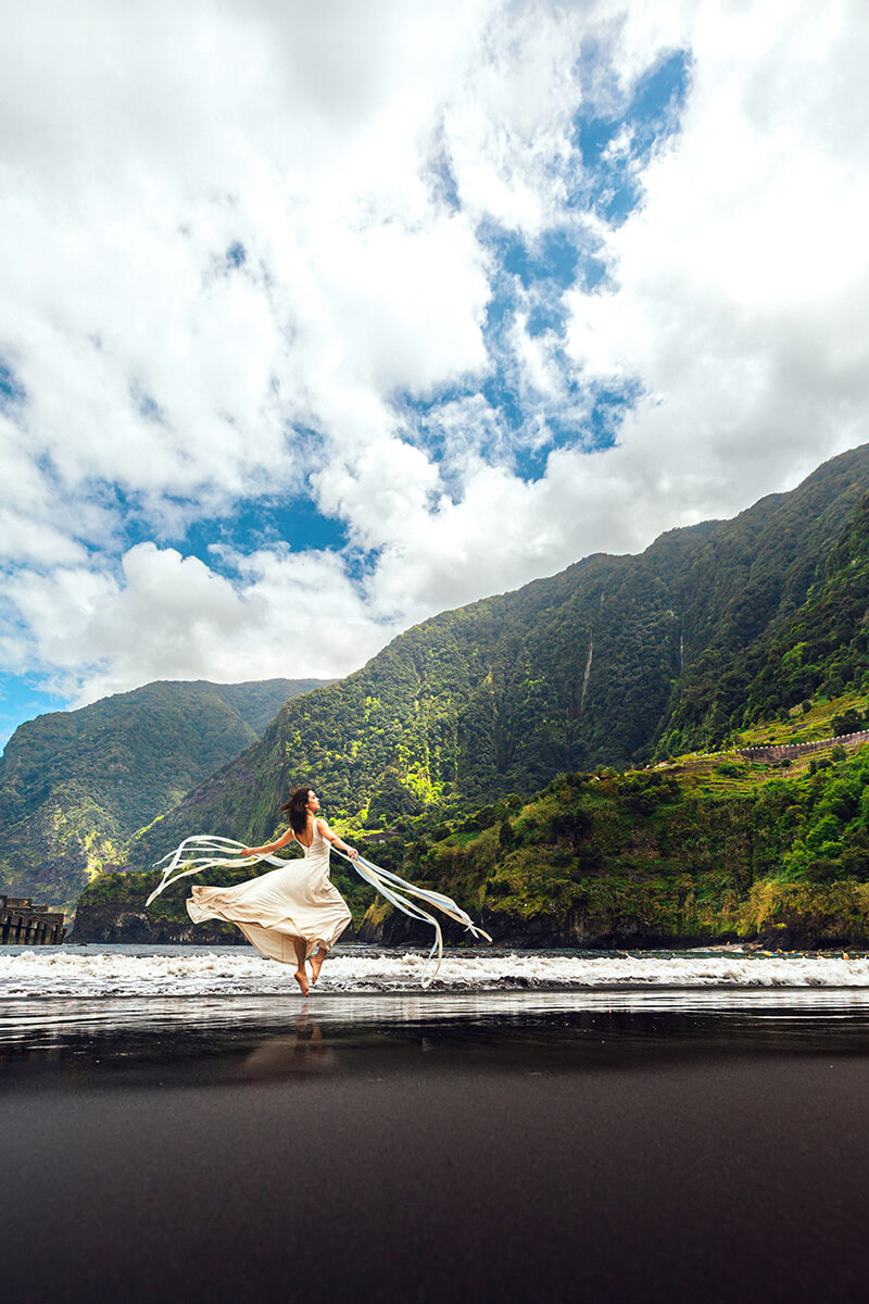Frau im weißen Kleid tanzt am Strand von Seixal – künstlerisches Portrait voller Emotion